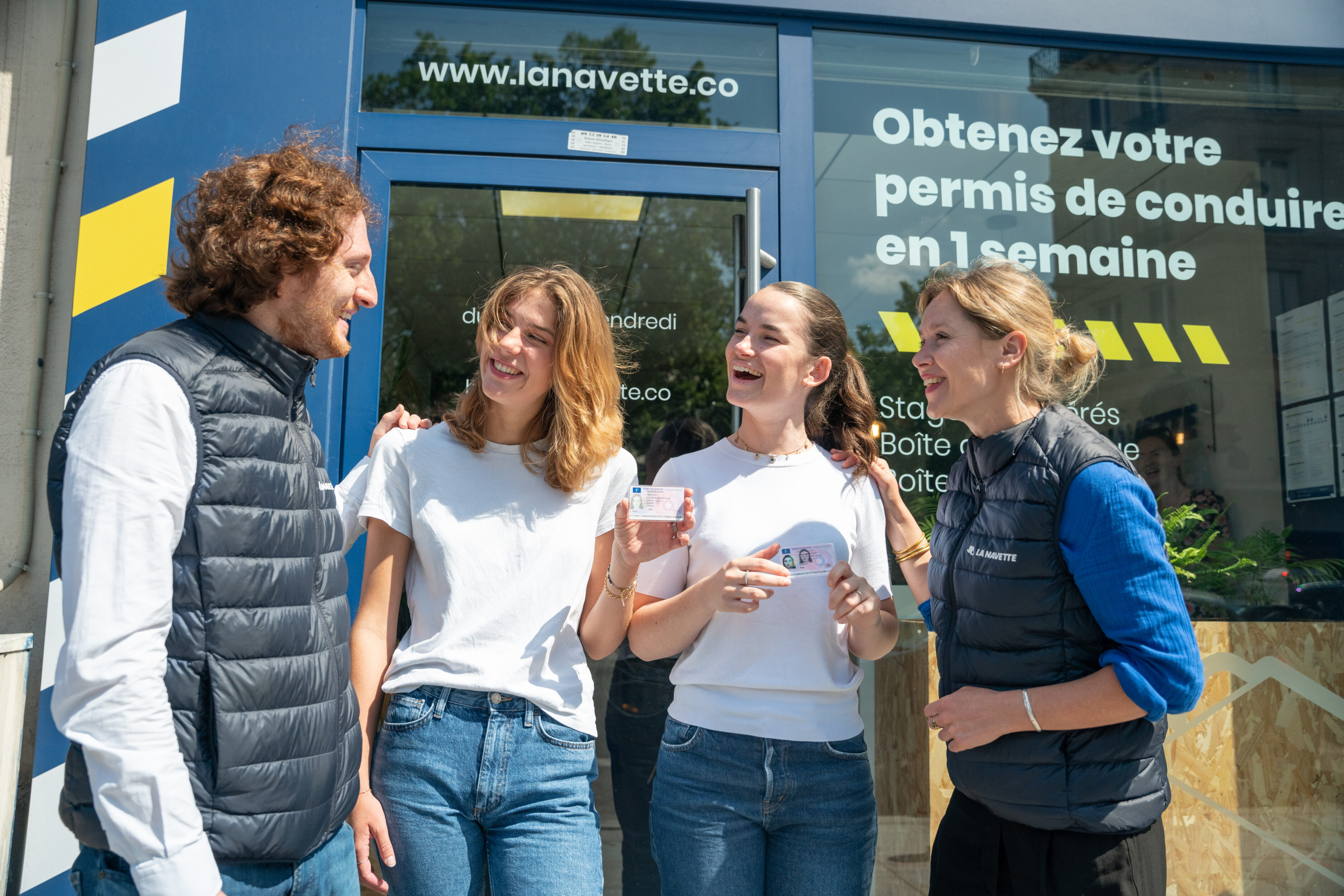 Deux élèves et leurs moniteurs avec le permis en mains.