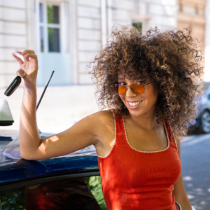 Elève appuyée sur une voiture avec les clés en mains