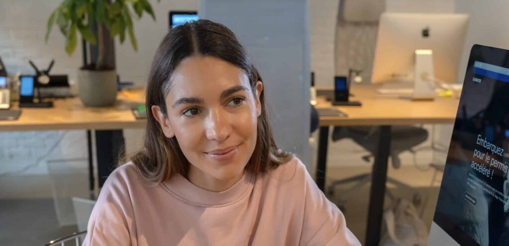 jeune fille avec sweat shirt rose dans le bureau de l'auto-école La Navette