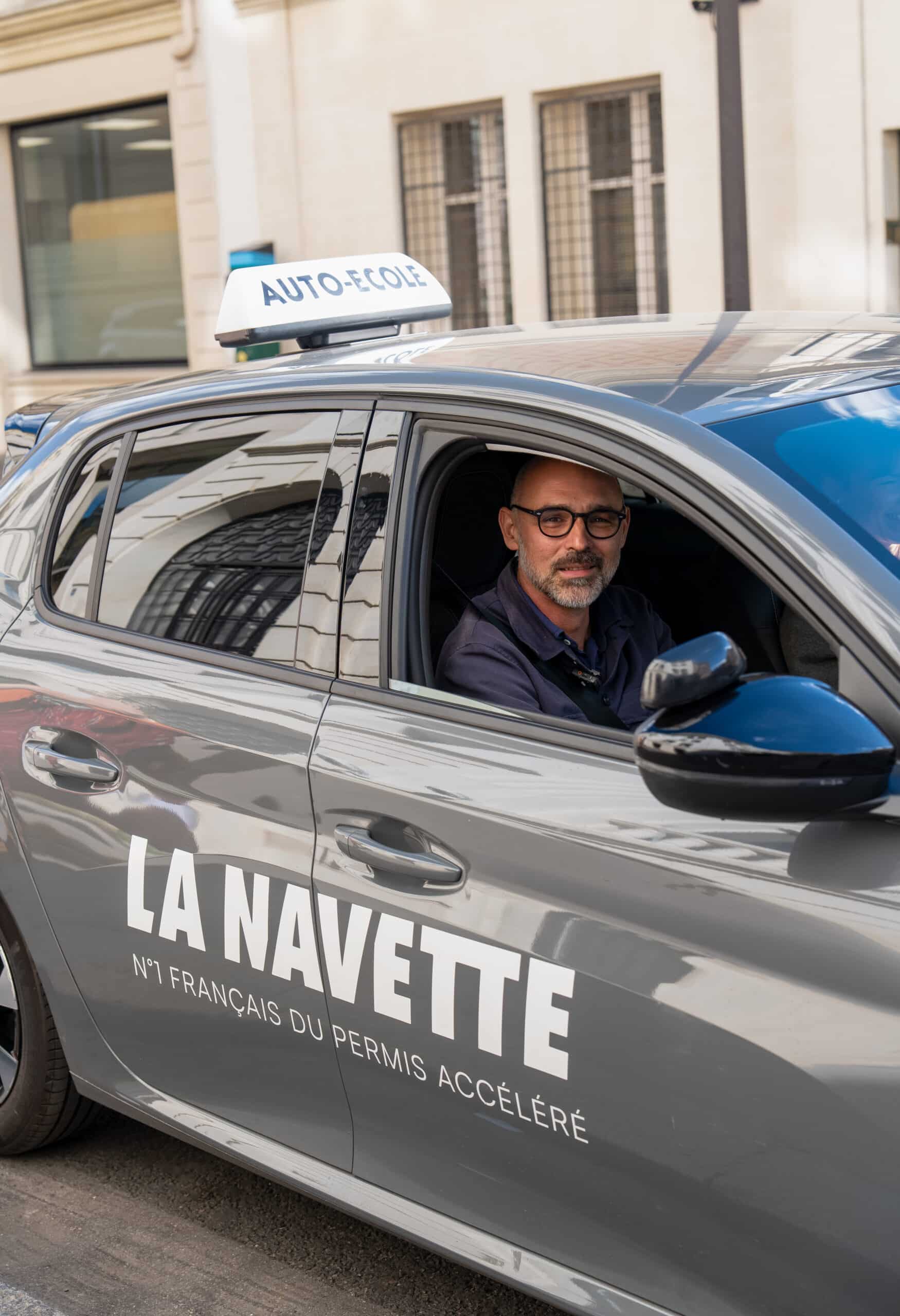 Moniteur dans une voiture floquée La Navette