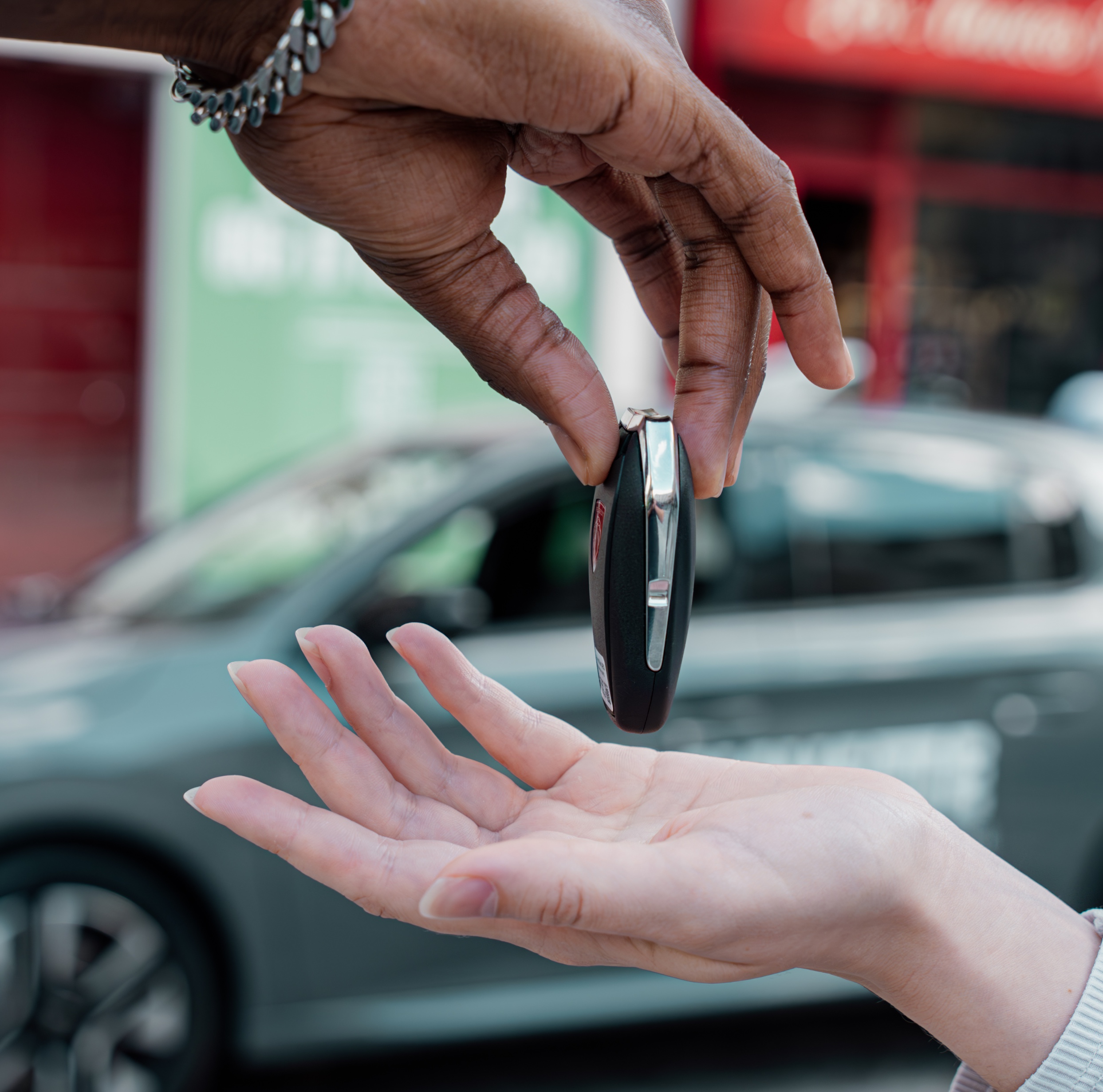 une main donne une clé de voiture à une autre main