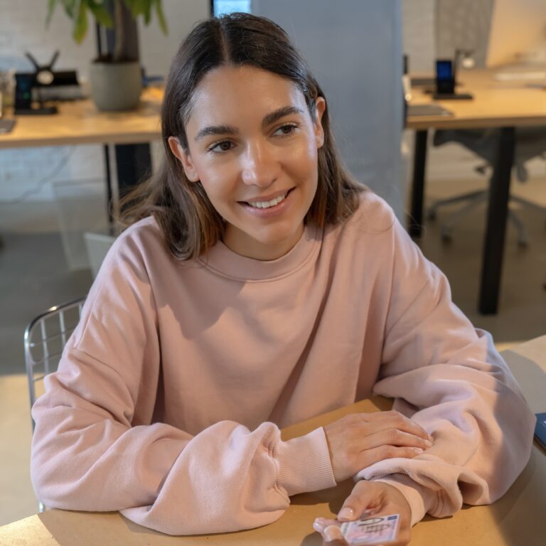 une jeune fille assise à un bureau donne sa carte d'identité