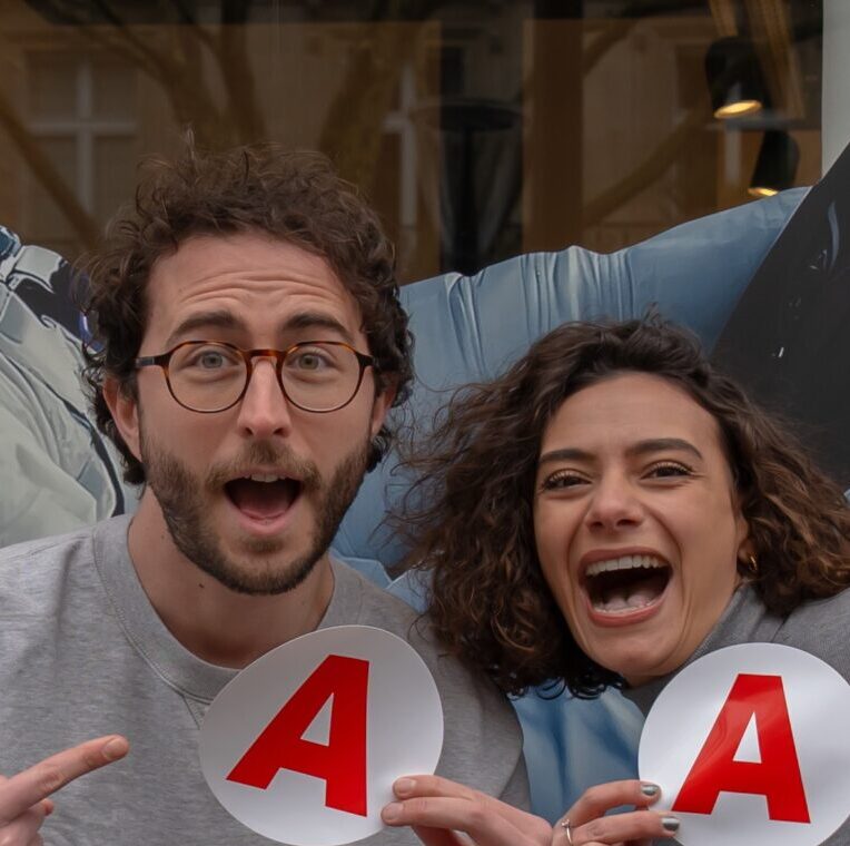 un jeune homme et une jeune femme , dans la rue, montrent leurs disques jeunes conducteurs avec joie.