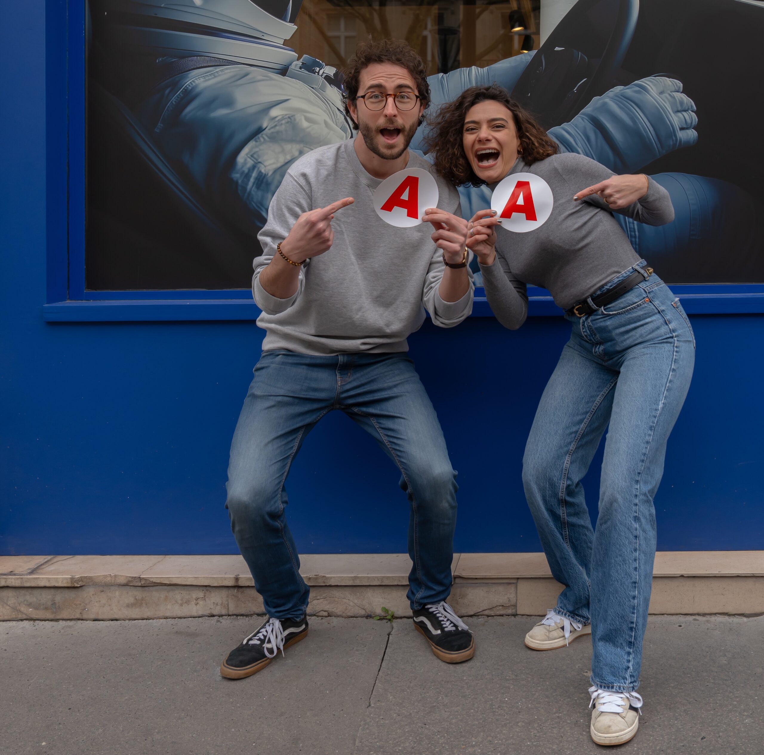 un jeune homme et une jeune femme , dans la rue, montrent leurs disques jeunes conducteurs avec joie.