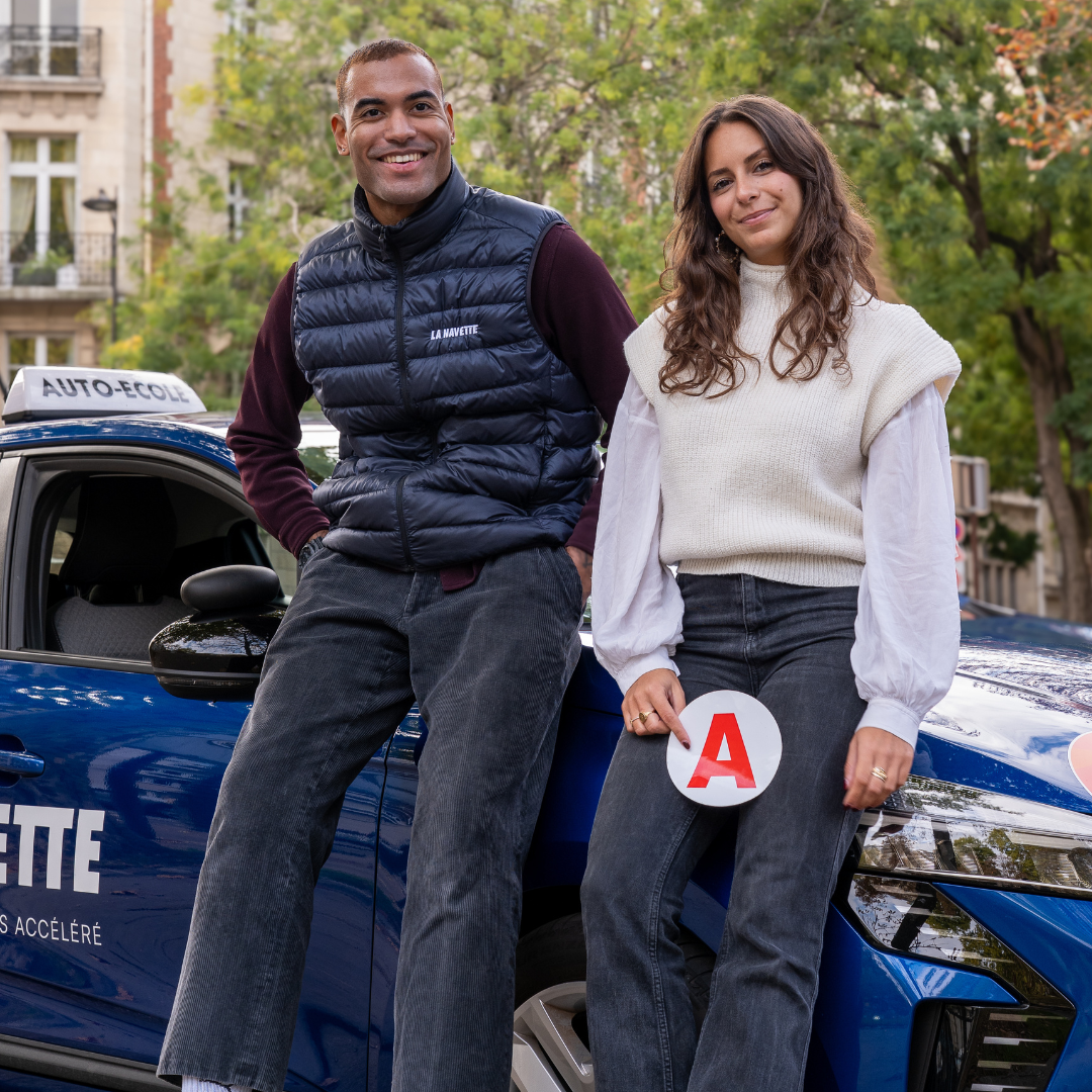 Enseignant et son élève qui porte un 'A' du permis dans les mains
