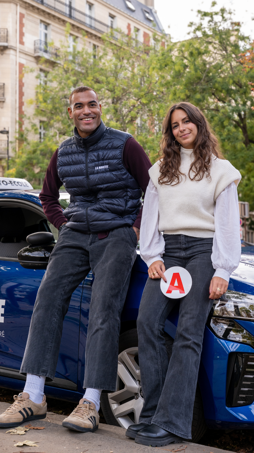 Enseignant et son élève qui porte un 'A' du permis dans les mains