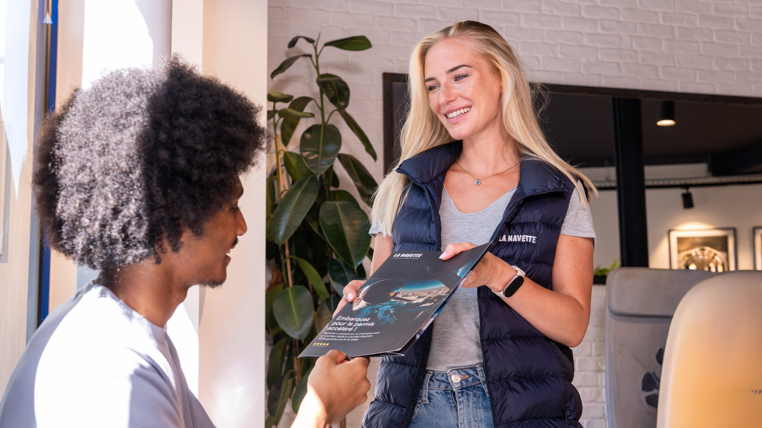 Commercial qui donne la documentation La Navette à un élève